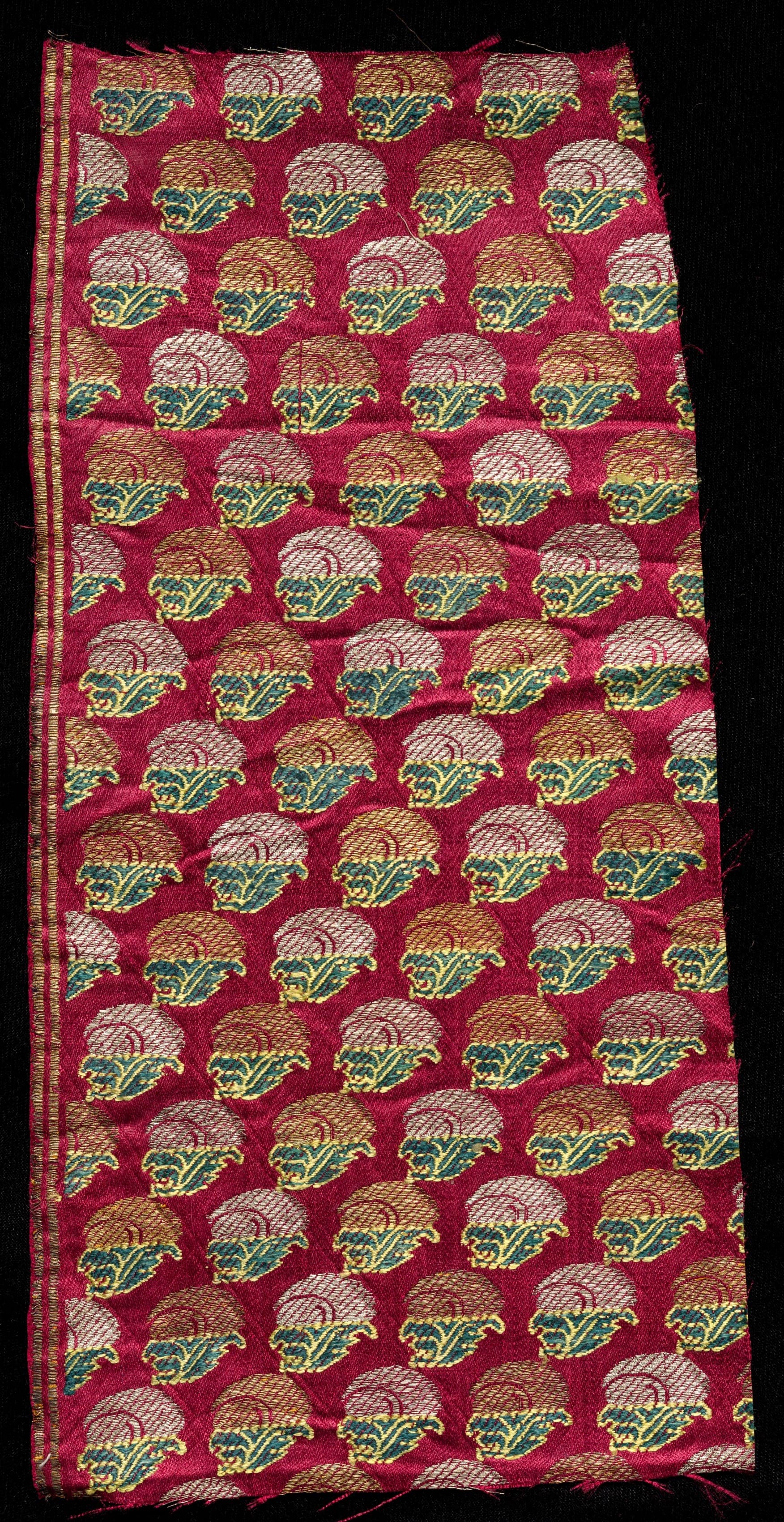 A 19th-century Surat brocade fragment, red silk woven with flower motifs in gold, green and pink